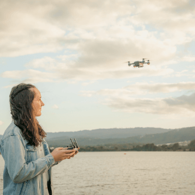 Woman flying a drone over water